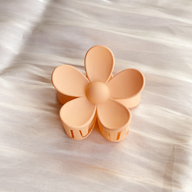Peach summer candy color colorful flower hair clip with frosted finish on fabric background
