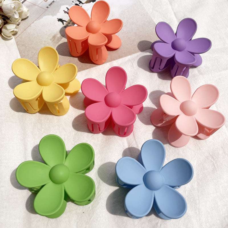 Set of colorful flower hair clips in pastel shades including yellow, pink, orange, purple, green, blue, and light pink