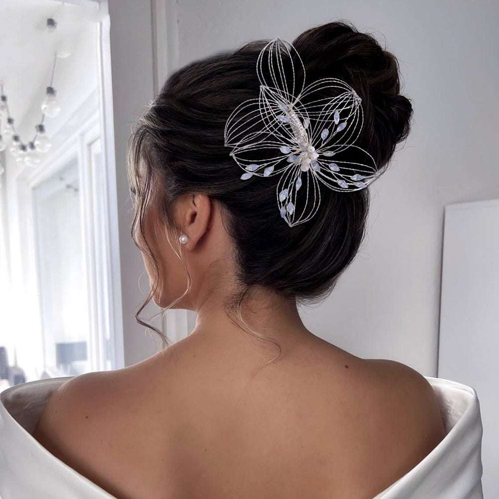 Elegant leaf design hair comb bridal headdress with delicate wire flower worn in updo hairstyle