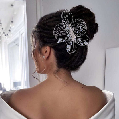 Elegant leaf design hair comb bridal headdress with delicate wire flower worn in updo hairstyle