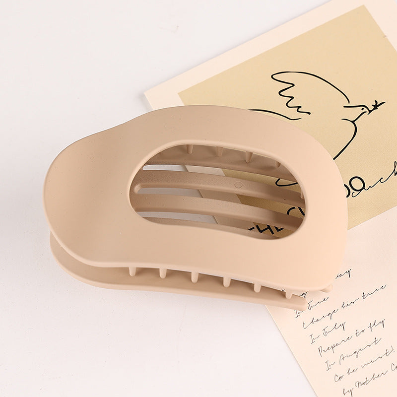 Beige flat oval hair barrette for back head updo with smooth matte finish and open center design