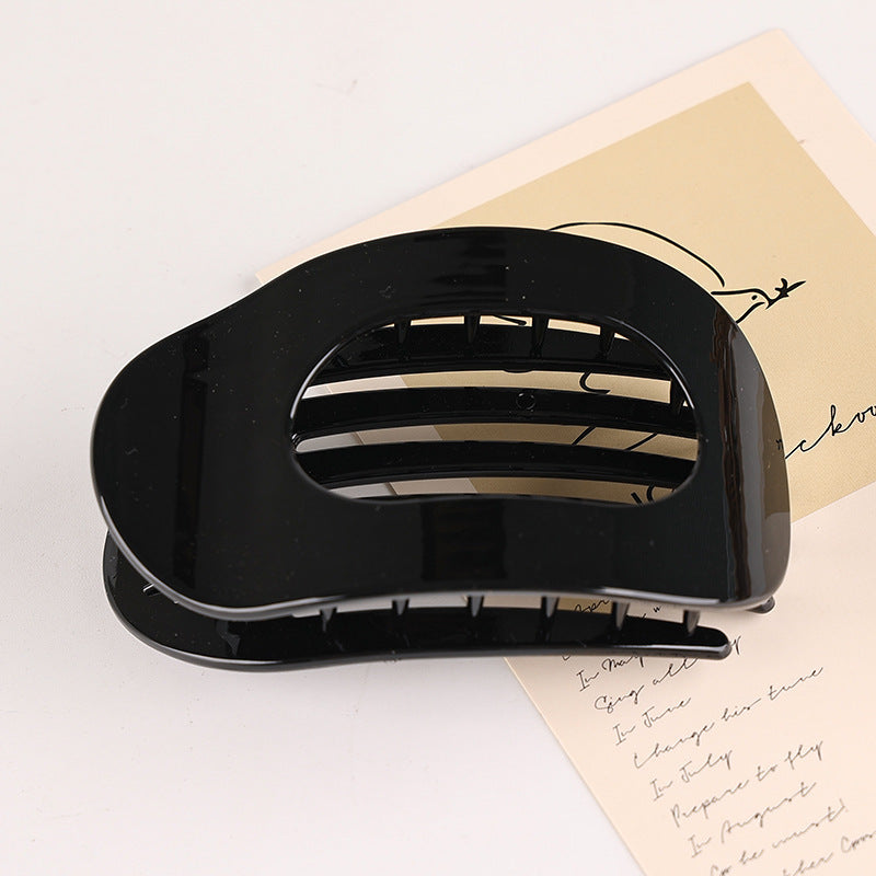 Black flat oval hair barrette with glossy finish for securing back head updo hairstyles