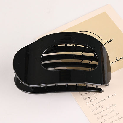 Black flat oval hair barrette with glossy finish for securing back head updo hairstyles