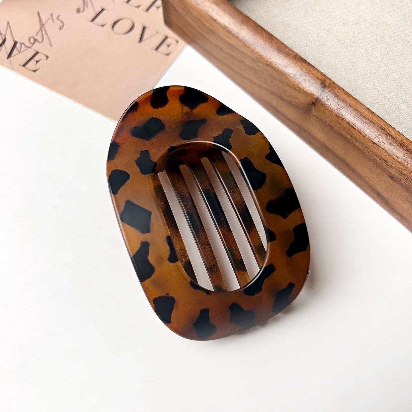 Flat oval hair barrette with tortoiseshell pattern for back head updo styling