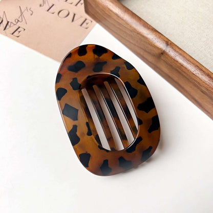 Flat oval hair barrette with tortoiseshell pattern for back head updo styling