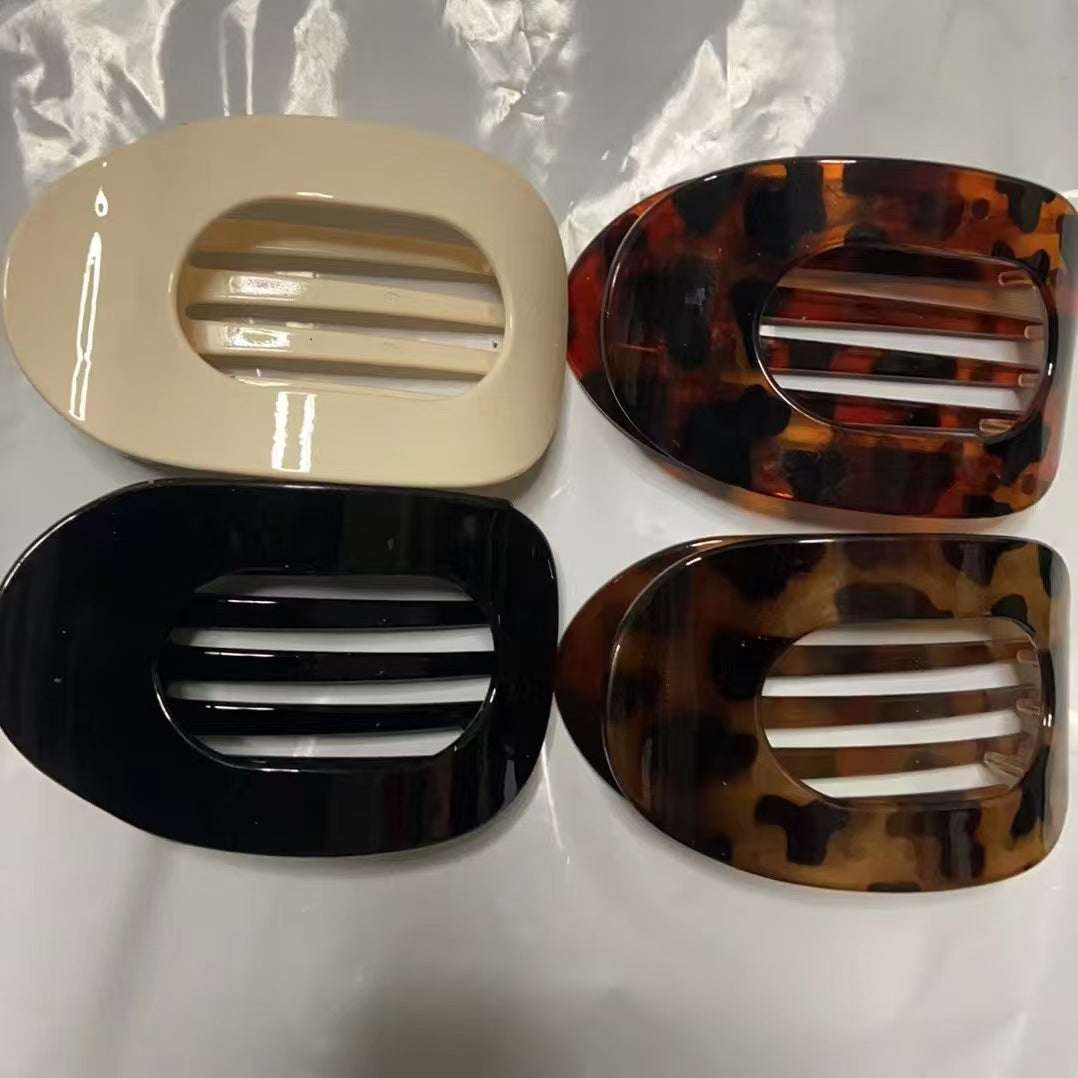 Set of four flat oval hair barrette clips in beige, tortoiseshell, black, and brown patterns
