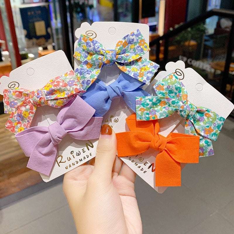 Luxury children's hairclips in assorted colors and floral patterns, perfect for girls' hair styling.