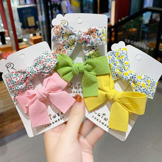 Set of luxury children's hairclips in floral and solid colors featuring bow designs