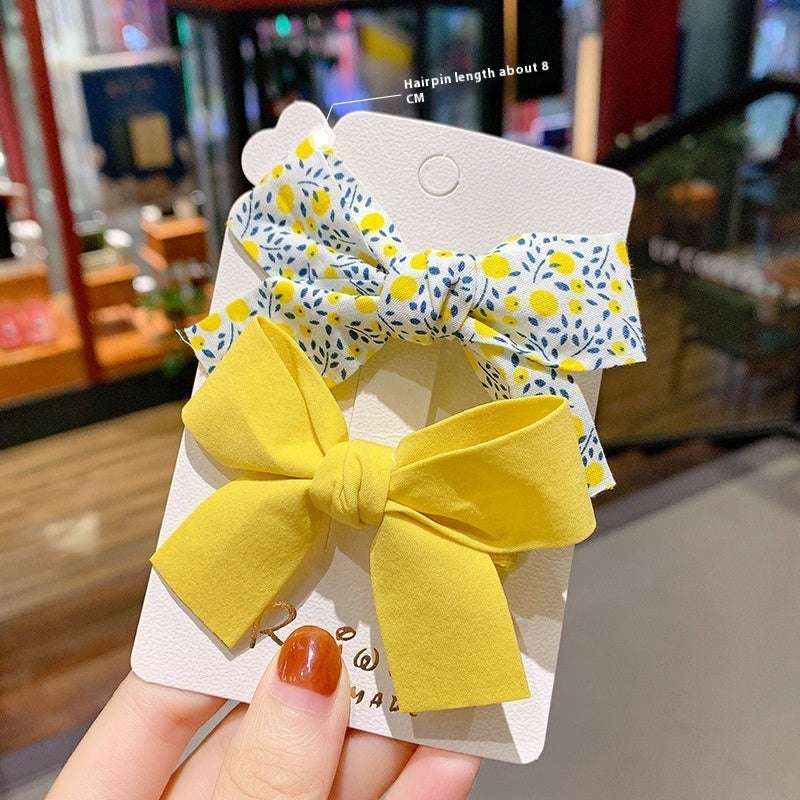 Luxury children's hairclips featuring yellow and floral fabric bows for stylish girls