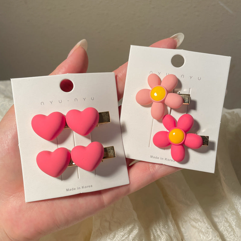 Set of heart-shaped hairclip in pink with matching flower clips for stylish hairdos