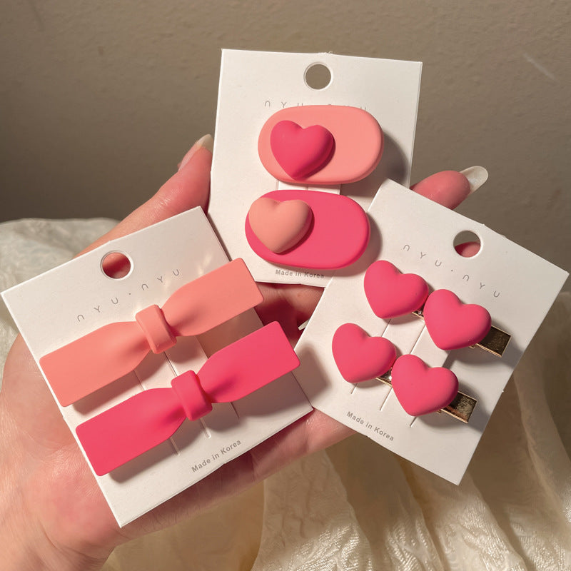 Pink heart-shaped hairclip set featuring various styles and sizes for stylish hairstyles