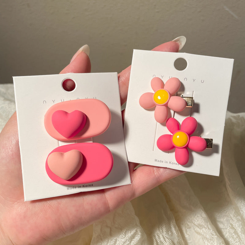 Heart-shaped hairclip set in pink and red with floral designs for stylish hair accessories