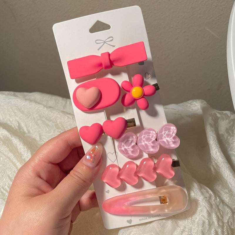 Collection of colorful hair accessories including a heart-shaped hairclip and various pink clips