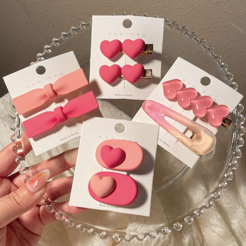 Collection of pink heart-shaped hairclip accessories displayed on a glass plate