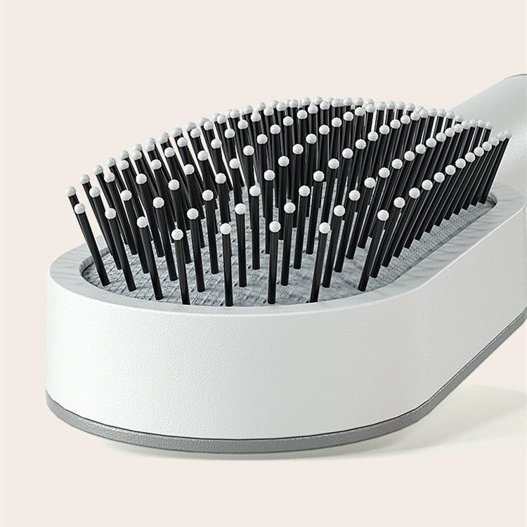 One-key cleaning hairbrush with ergonomic design and flexible bristles for easy hair detangling