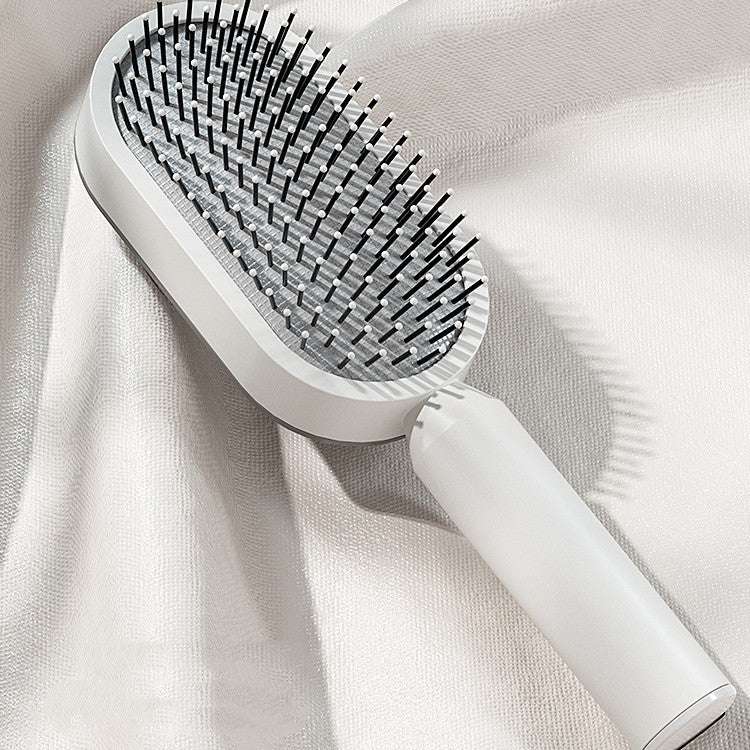 One-key cleaning hairbrush in sleek white design with ergonomic handle and fine bristles