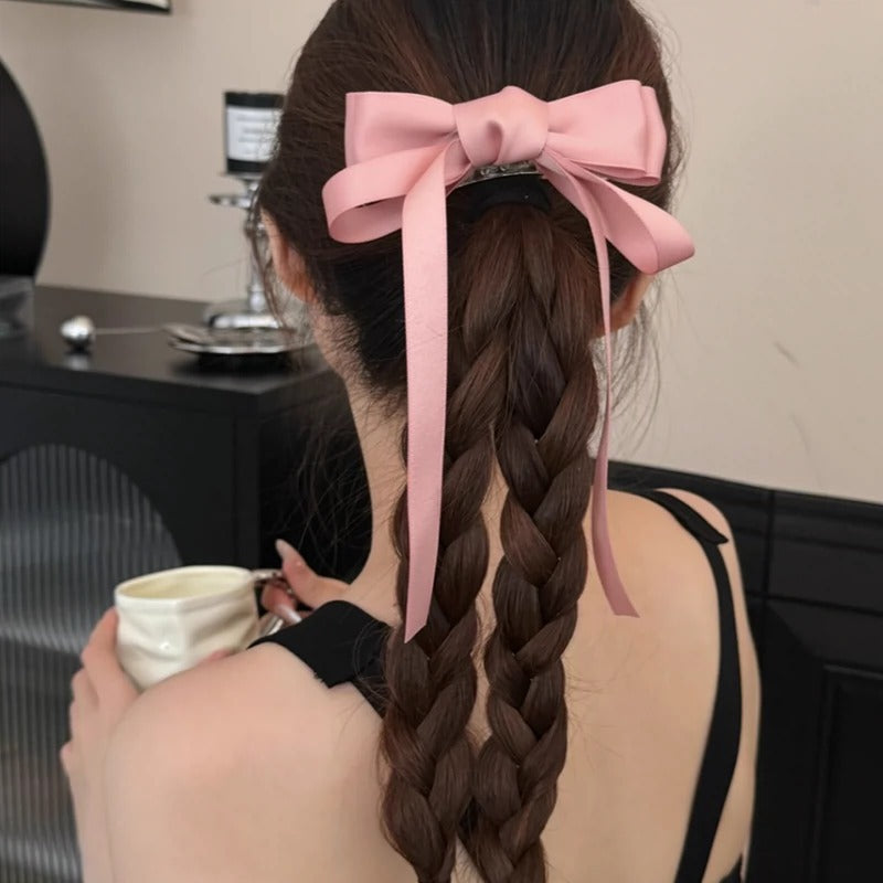 Stylish women's hair with a large pink bow and braid featuring premium French barrettes for women
