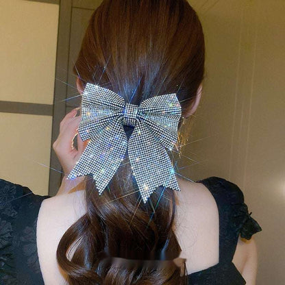 Sparkling hair clip in a bow shape worn on a dark brunette hairstyle for a stylish look