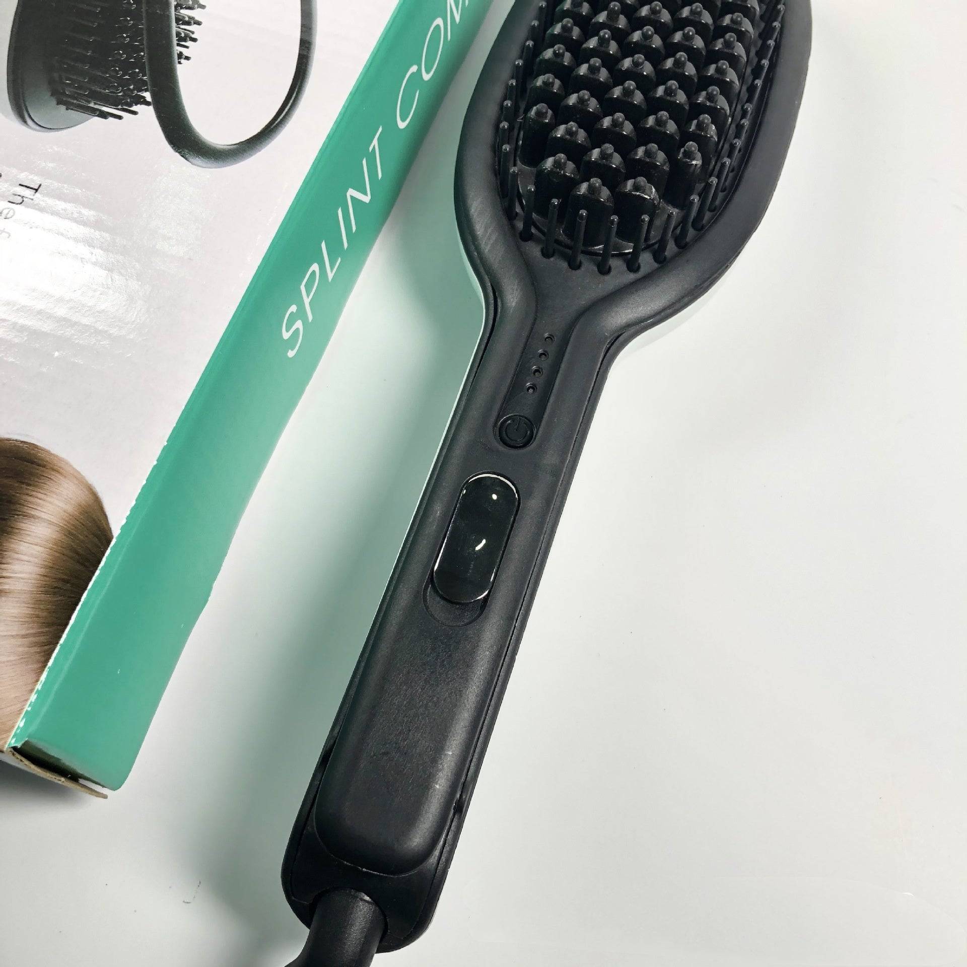 Black electric professional straight hair brush with heating elements and control buttons on handle